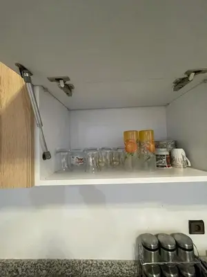 a kitchen shelf with glasses and bowls on it at Appartement bien équipé in Marrakech