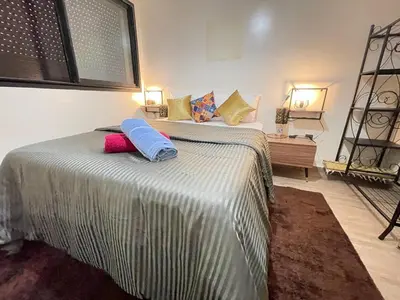 a bedroom with a bed with two pillows on it at Appartement bien équipé in Marrakech