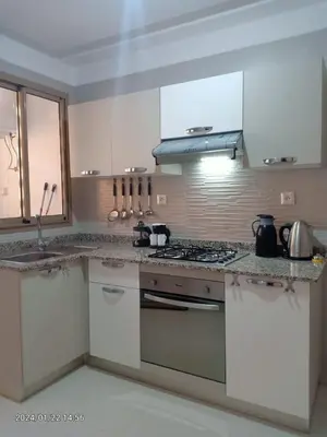 a kitchen with white cabinets and a stove top oven at Marrakech Luxury ATLAS in Marrakech