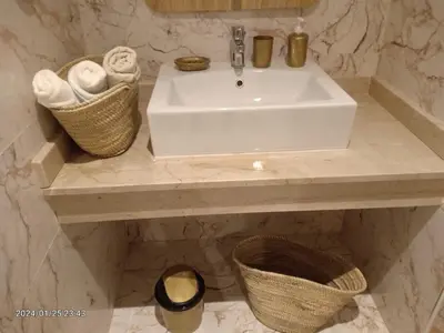 a bathroom with a sink and baskets of towels at Marrakech Luxury ATLAS in Marrakech