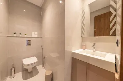 a white bathroom with a toilet and a sink at Luxe Urbain - 3 Chambres en Centre-Ville in Marrakech