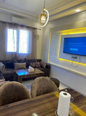 a living room with chairs and a flat screen tv at Au cœur de la Ville Rouge in Marrakech