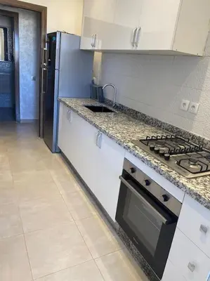 a kitchen with a stove and a refrigerator at Au cœur de la Ville Rouge in Marrakech