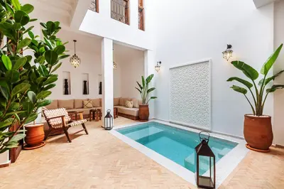 a swimming pool in a living room with plants at Riad Dar Yamina Exclusif in Marrakech