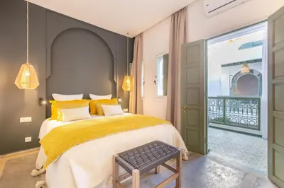 a bedroom with a large bed with a yellow blanket at Dar KAJAM -Privatized Riad -10mn from Jamaa Al Fna in Marrakech
