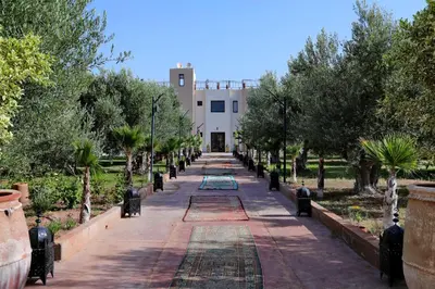 a walkway leading to a white building with trees at Villa Sahar in Marrakech