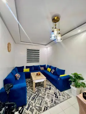 a living room with a blue couch and a table at Marrakech Airport Appart in Marrakech