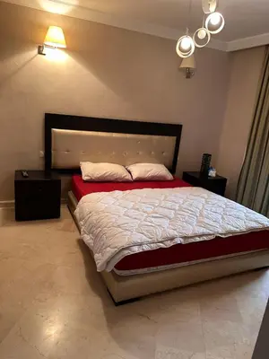 a bedroom with a large bed with a large headboard at Appartement meublé à River palm in Marrakech