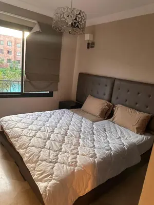 a large bed in a bedroom with a window at Appartement meublé à River palm in Marrakech