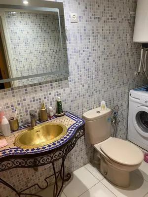 a bathroom with a sink and a toilet and a mirror at Apparemment tout confort in Marrakech