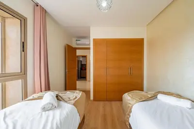 a bedroom with two beds and a closet at Exceptional Golf Apartment - 2 Bedrooms Prestigia Marrakech in Marrakech