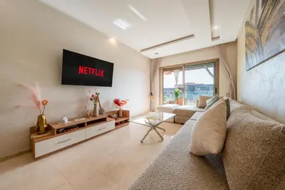 a living room with a couch and a tv at Exceptional Golf Apartment - 2 Bedrooms Prestigia Marrakech in Marrakech