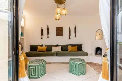 a living room with a green couch and a fireplace at Riad BAB 19 in Marrakech