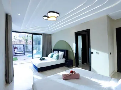 a bedroom with two beds and a large window at VILLA Wa EXCLUSIVE MARRAKECH in Marrakech