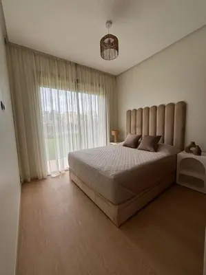 a bedroom with a large bed and a large window at Jubaea youmna in Marrakech