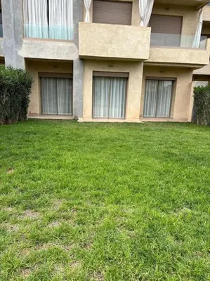 a grassy yard in front of a building at Jubaea youmna in Marrakech