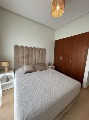 a bedroom with a large bed with a large headboard at Jubaea youmna in Marrakech