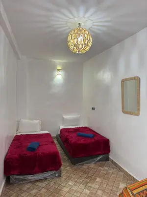 a bedroom with two beds and a chandelier at Maison Cascada 2 in Marrakech