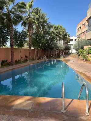 a large swimming pool with palm trees in the background at Luxury apartment in Marrakech in Marrakech