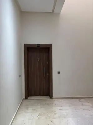 a wooden door in a white room with a tile floor at Luxury apartment in Marrakech in Marrakech