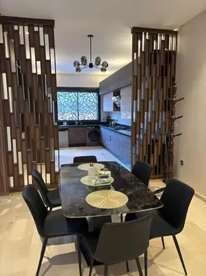 a dining room with a black table and chairs at Luxury apartment in Marrakech in Marrakech