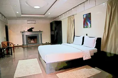 a bedroom with a large bed and a fireplace at Gîte AYA in Marrakech
