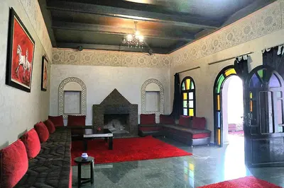 a living room with red couches and a fireplace at Gîte AYA in Marrakech