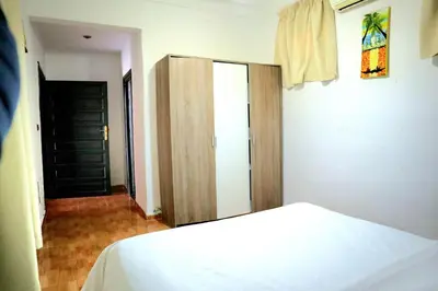 a bedroom with a white bed and a closet at Gîte AYA in Marrakech