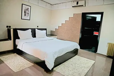 a bedroom with a bed with white sheets and a staircase at Gîte AYA in Marrakech