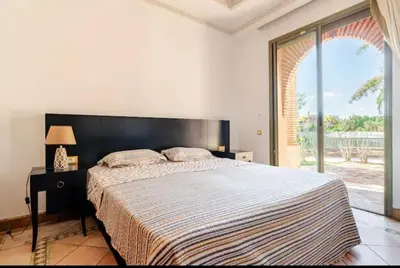 a bedroom with a large bed and a large window at NATURALapartmentLARGE pool in Marrakech