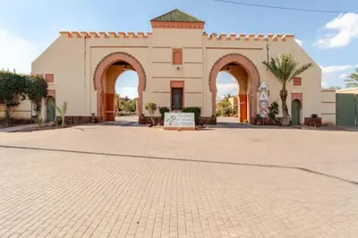 a building with arches and a sign in front of it at NATURALapartmentLARGE pool in Marrakech