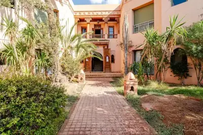 a house with a brick path in front of a building at NATURALapartmentLARGE pool in Marrakech