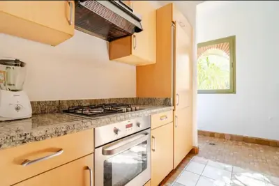 a kitchen with wooden cabinets and a stove top oven at NATURALapartmentLARGE pool in Marrakech