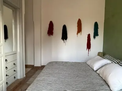a bedroom with a bed and some coats on the wall at Appartement dans la palmeraie in Marrakech