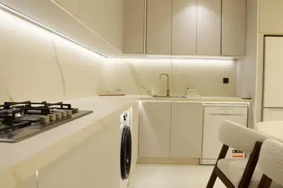 a white kitchen with a stove and a sink at Superbe Duplex piscine chauffée in Marrakech