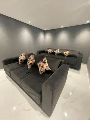 a black couch with pillows on it in a room at Luxueuse villa au Golf Amelkis - 5 suites in Marrakech