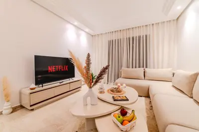 a living room with a white couch and a tv at Luxury Apartment 3 Bedroom in CityCenter Marrakech in Marrakech