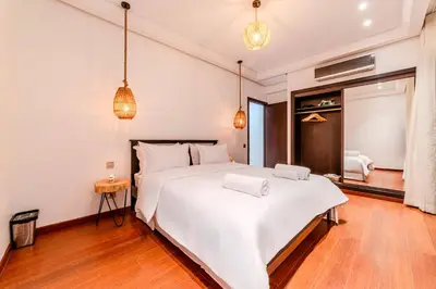 a bedroom with a large white bed and wooden floors at Luxury Apartment 3 Bedroom in CityCenter Marrakech in Marrakech