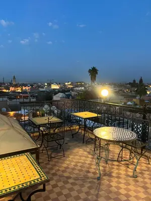 a group of tables and chairs on a balcony at night at Habibi Riad&Hostel in Marrakech
