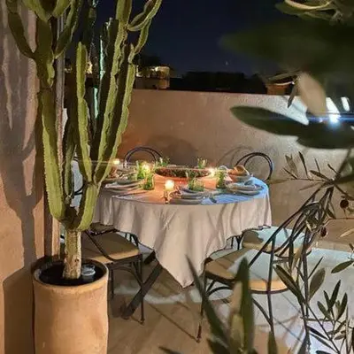 a table with plates and candles on it with a plant at Riad 17 DAR CHAMAR in Marrakech