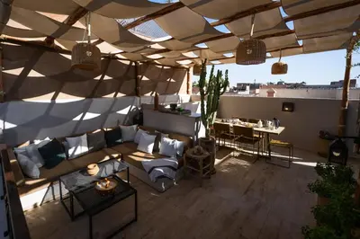 a rooftop patio with a couch and a table at Riad 17 DAR CHAMAR in Marrakech