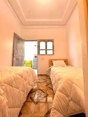 two beds sitting next to each other in a bedroom at cosy appartement a marrakech in Marrakech