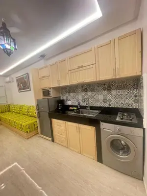 a kitchen with a washing machine and a yellow couch at cosy appartement a marrakech in Marrakech