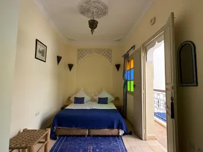 a bedroom with a bed with a blue comforter at Riad Lou Kasbah in Marrakech