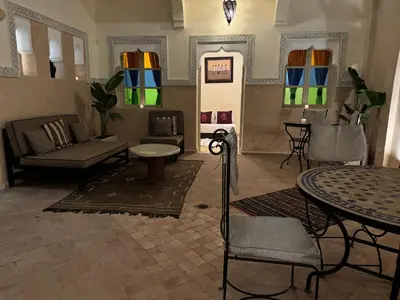 a living room with a couch and tables and windows at Riad Lou Kasbah in Marrakech