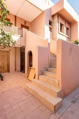 a house with a staircase in front of it at Marrakech flat with swimming pool & sunny garden in Marrakech