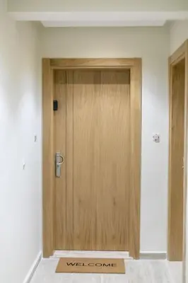 a wooden door in a room with a welcome mat at Chic urbain en plein centre in Marrakech