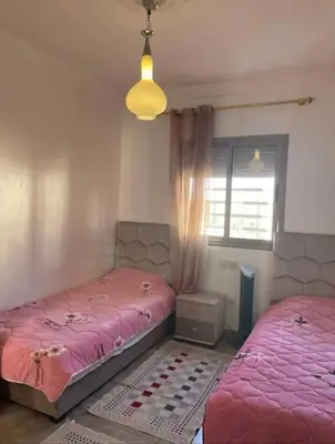 a bedroom with two twin beds and a window at Appart in Marrakech 5G in Marrakech