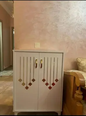 a white cabinet with swords on it in a room at Appart in Marrakech 5G in Marrakech