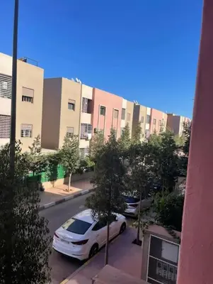 a white car parked in a parking lot in front of buildings at Appart in Marrakech 5G in Marrakech